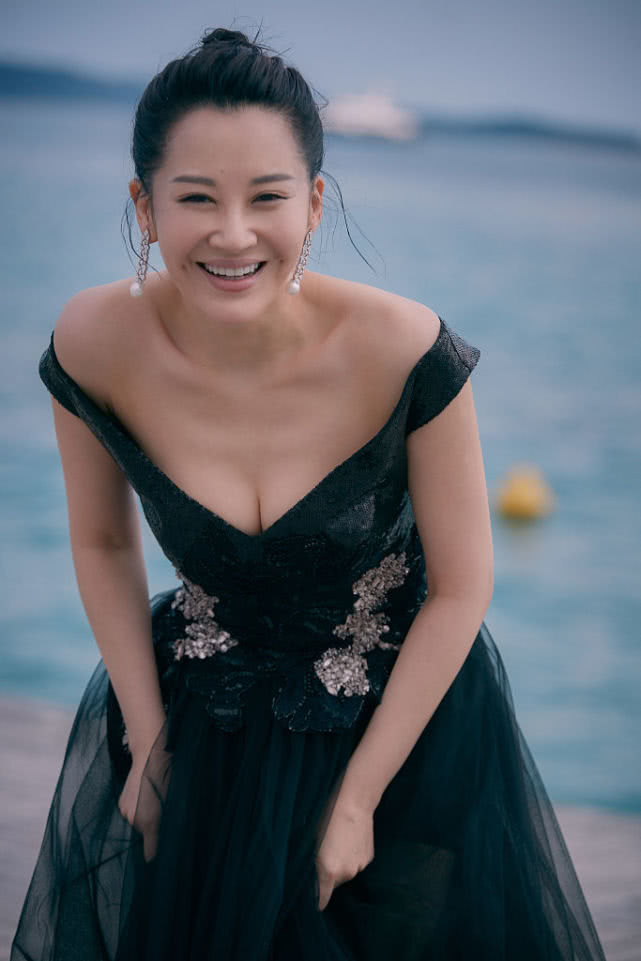 许晴戛纳拍写真肆意大笑酒窝抢镜 裙摆飞扬黑纱蒙面女人味十足